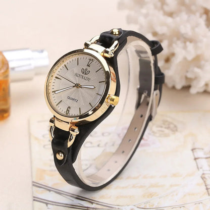 Wristwatch with black strap and gold accents on a decorative surface