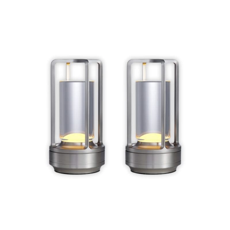 Two cylindrical metal lamps with glass covers on a white background