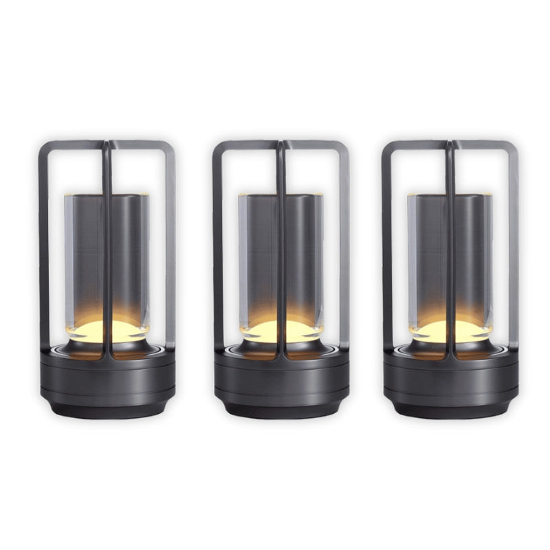 Three black cylindrical lanterns with glass covers on a white background