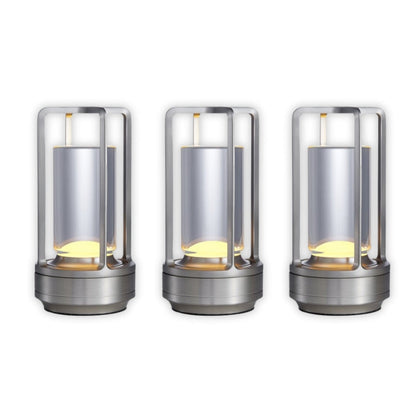 Three cylindrical metal lights with glass covers on a white background