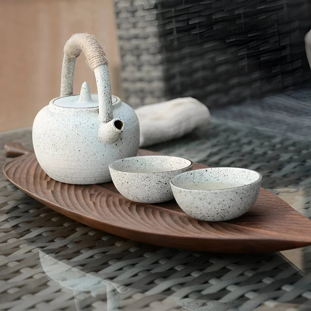 Josh & Tate - Leaf Shaped Wooden Serving Tray - Ceramic teapot and bowls on a wooden tray with a blurred background