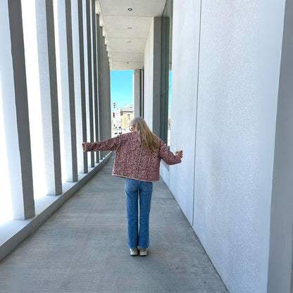 Person standing in a modern architectural hallway with open arms