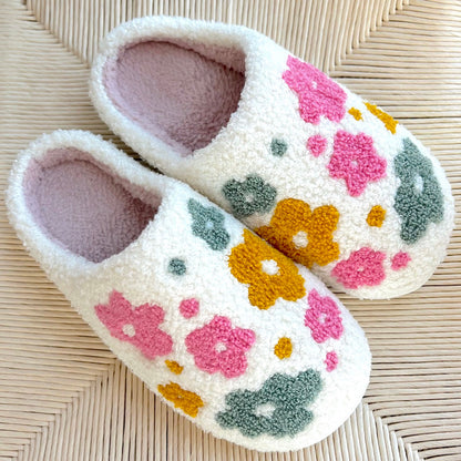 Pair of floral slippers on a woven surface