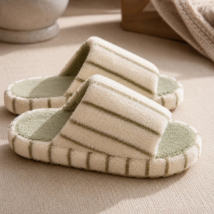 Josh & Tate - LoftWear™ Striped Slide Slippers - A pair of plush indoor slippers with cream-colored striped straps and pale green footbeds, styled on a textured beige fabric surface.