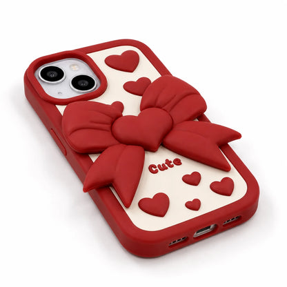 Josh & Tate - LoveBow™ Anti-Drop Phone Case - Red phone case with a 3D red bow and heart design on a cream-colored back panel, featuring the word 'Cute' in red text, shown on a white background.
