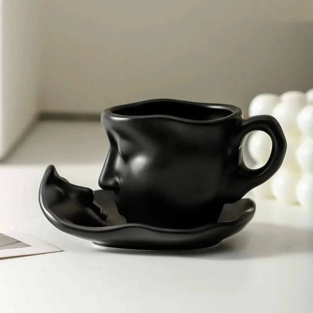 Josh & Tate - Lover's Gaze Reverie Coffee Ceramic Mug - Black ceramic cup and saucer shaped like a face on a light surface.