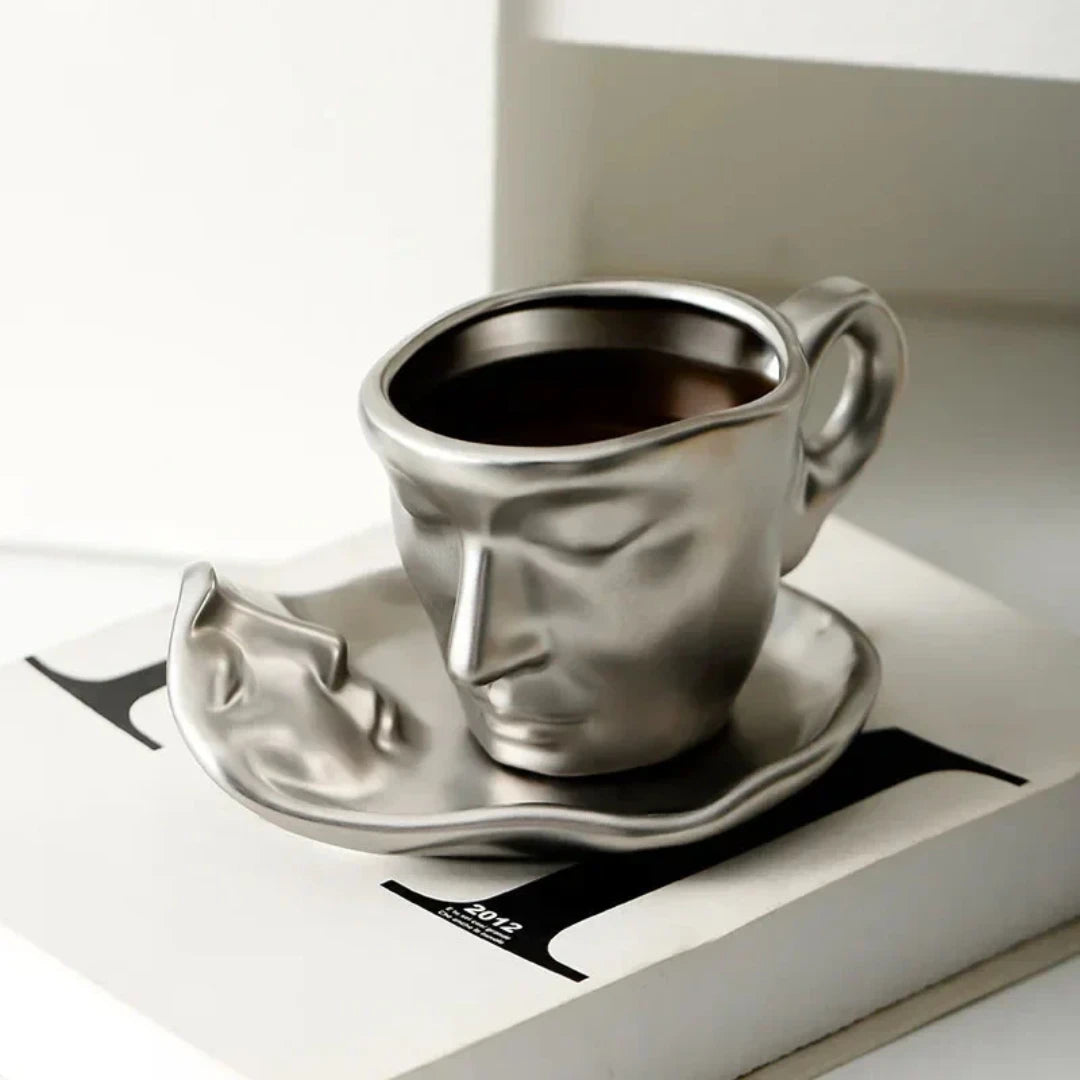 Josh & Tate - Lover's Gaze Reverie Coffee Ceramic Mug - Metallic face-shaped coffee cup and saucer on a magazine