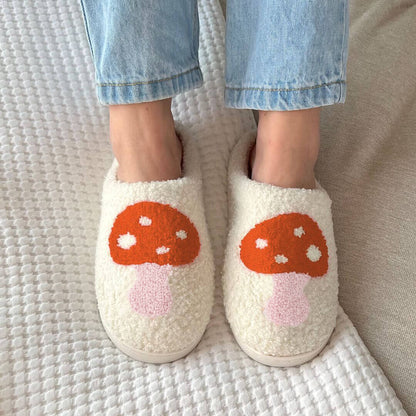 White slippers with mushroom design worn by a person on a textured surface