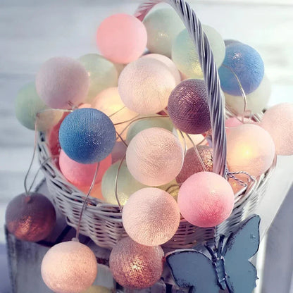 Colorful cotton ball string lights in a basket with a blurred background