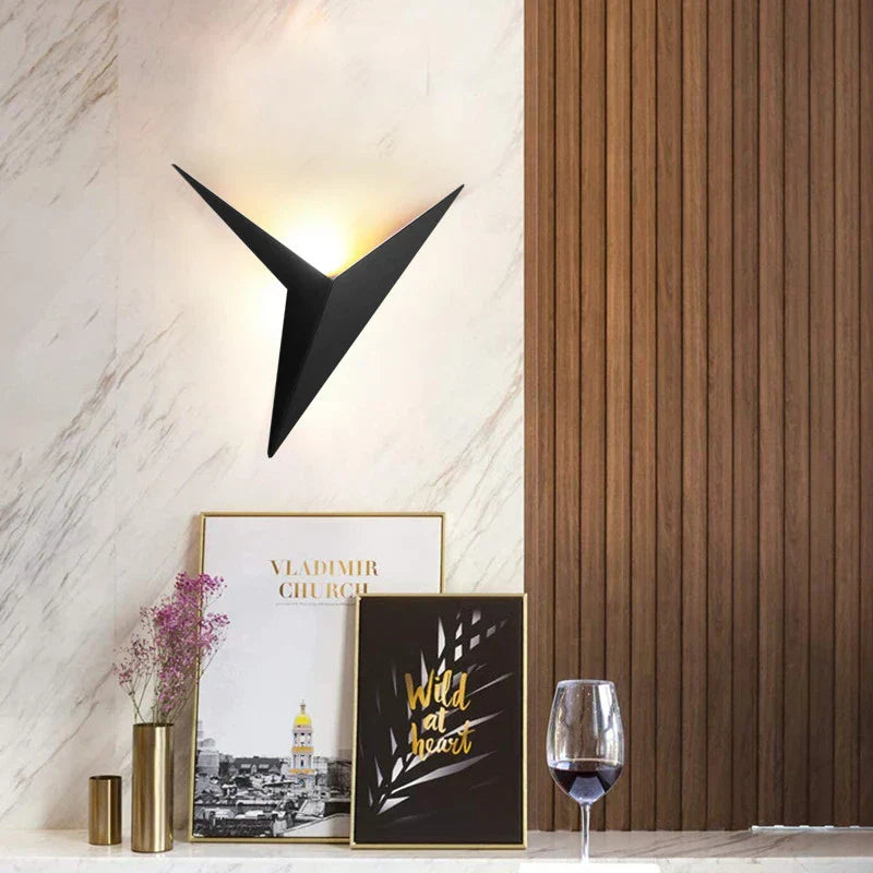 Modern wall sconce with decorative frames and a glass on a marble and wood background