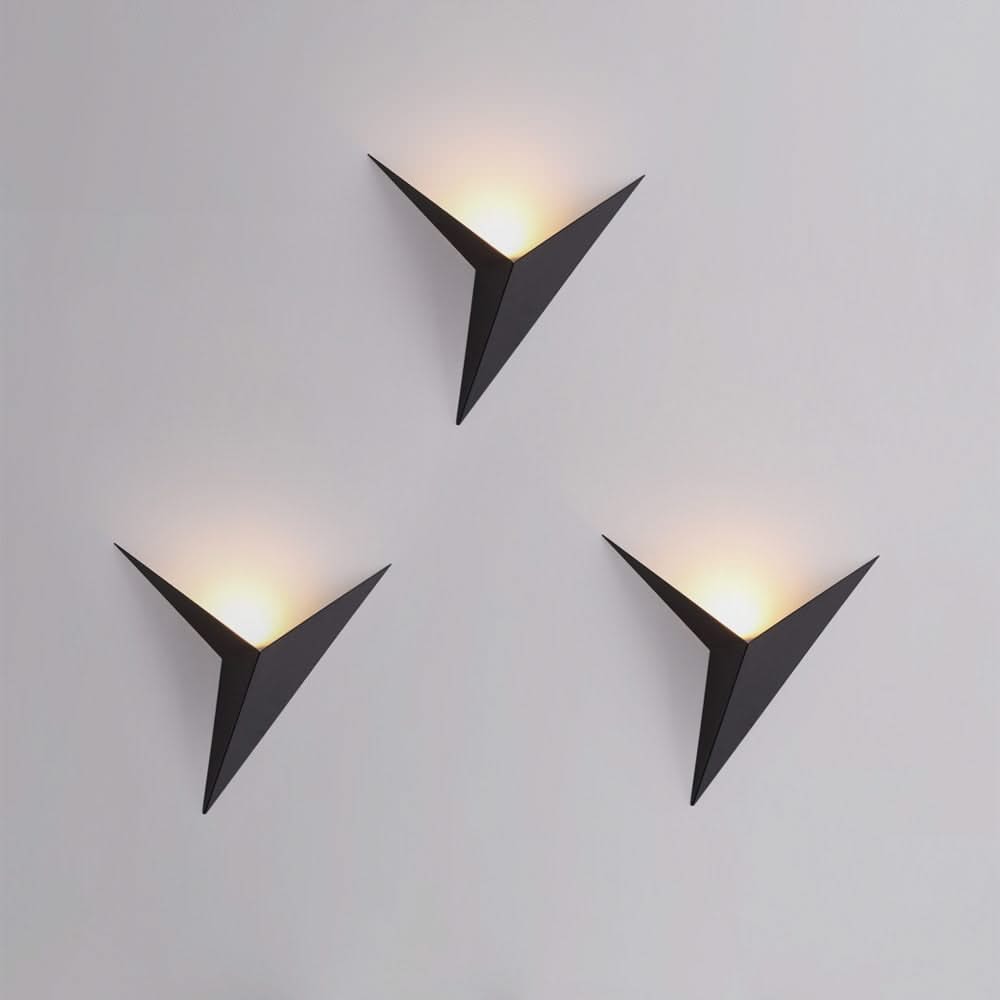 Three modern wall lights with triangular design on a gray background