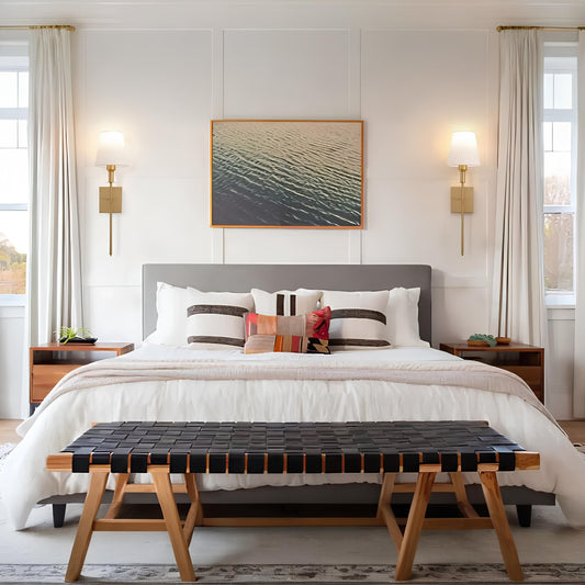 Modern bedroom with a bed, bench, and wall art