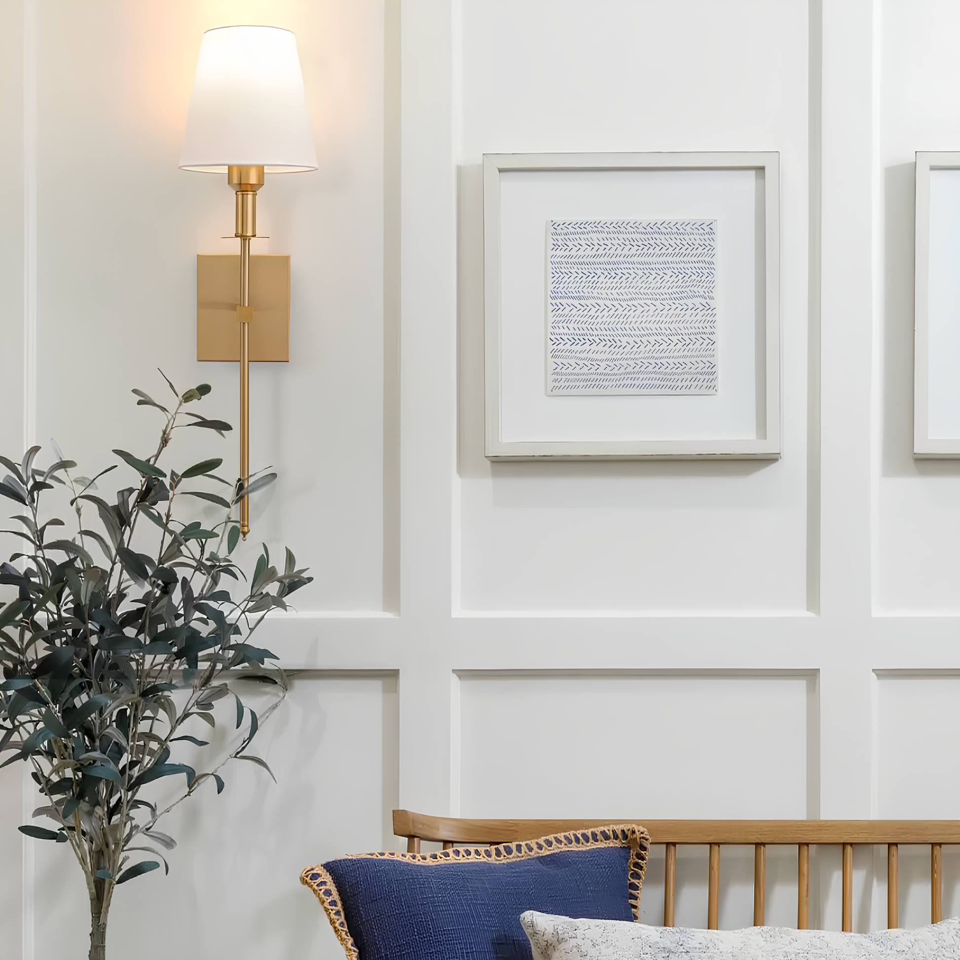 Decorative wall sconce, framed art, and plant in a room setting.