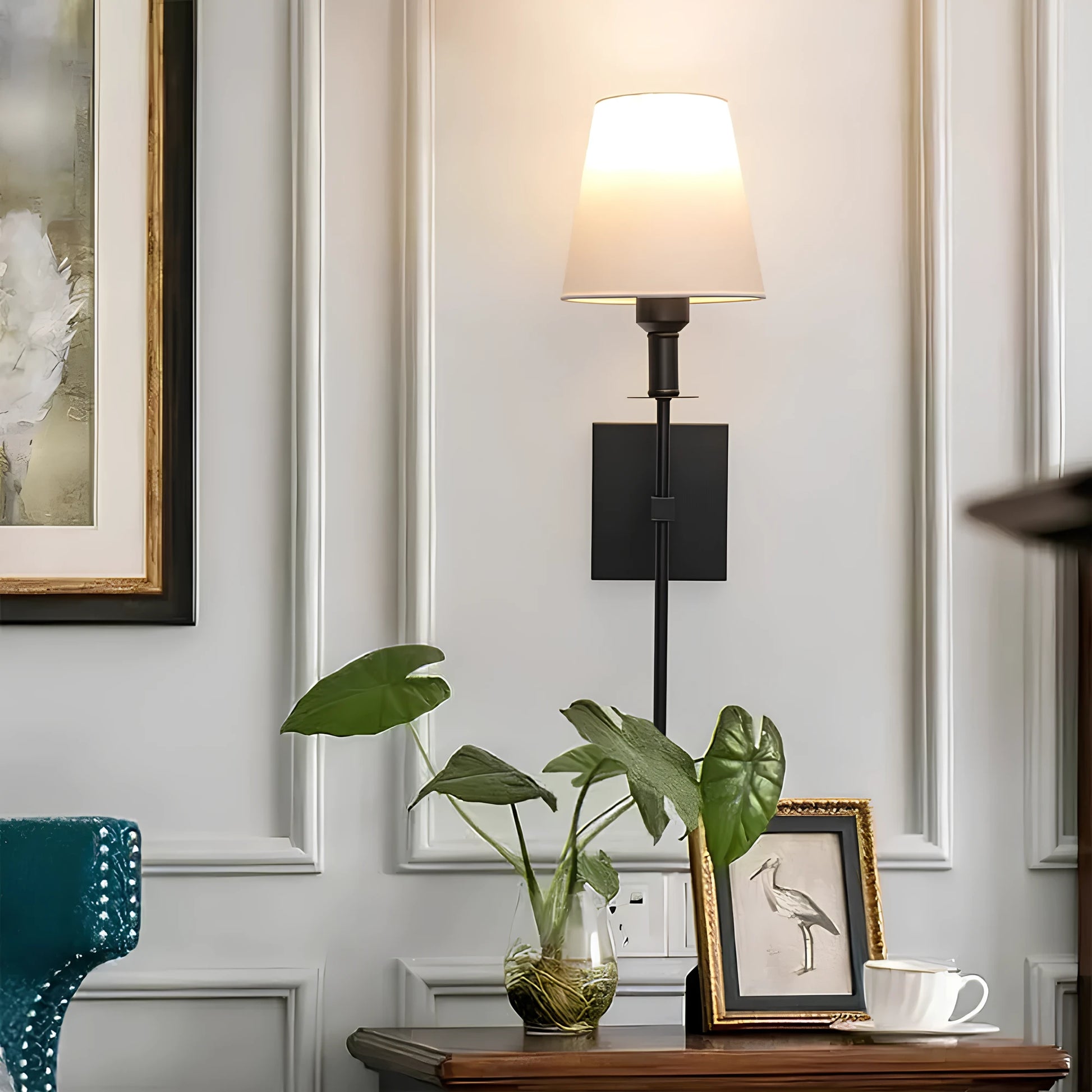Josh & Tate - LumaElegance Wireless Wall Lamp - Decorative wall sconce with a plant and framed picture on a wooden surface.