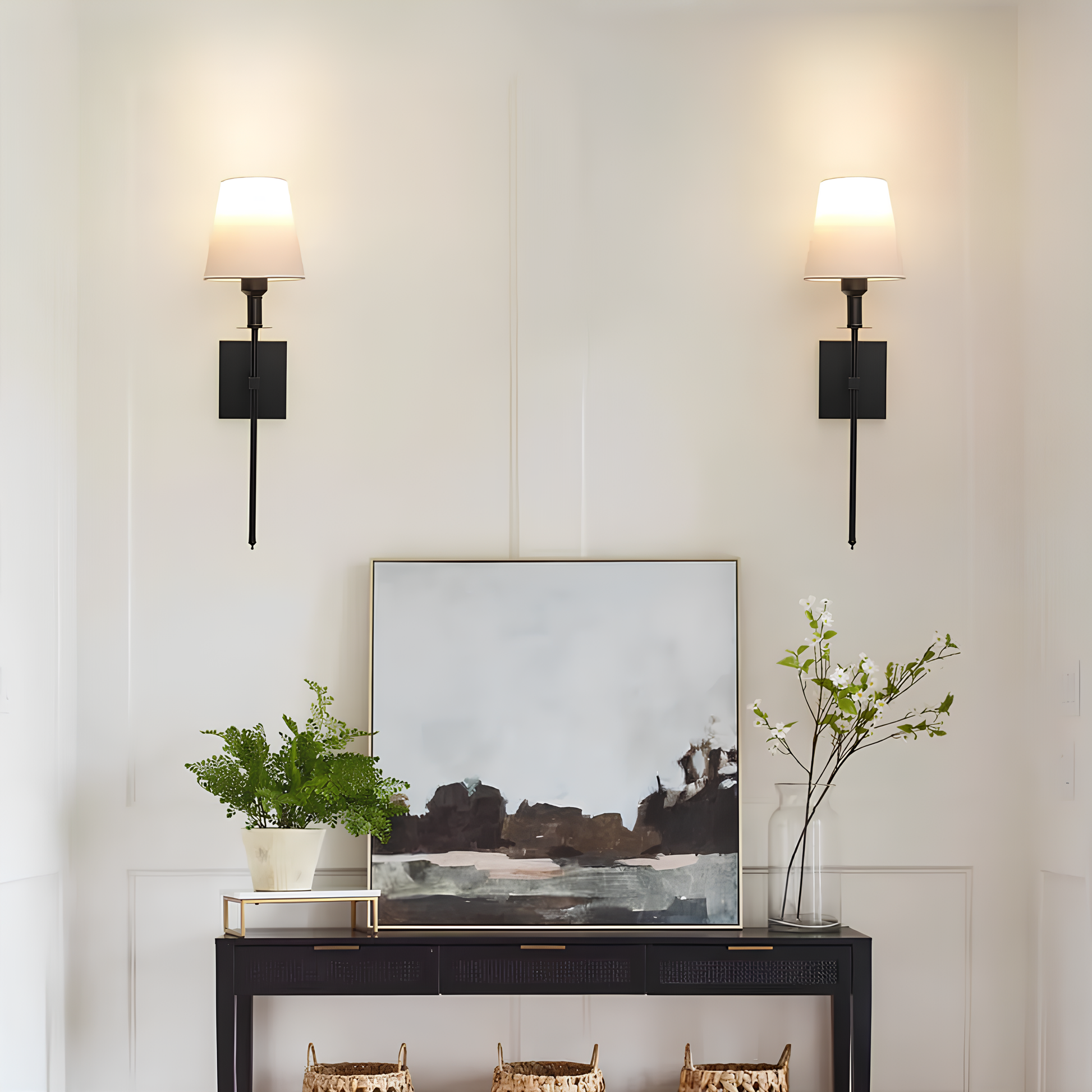 Modern interior with a console table, abstract painting, and decorative items against a light wall.