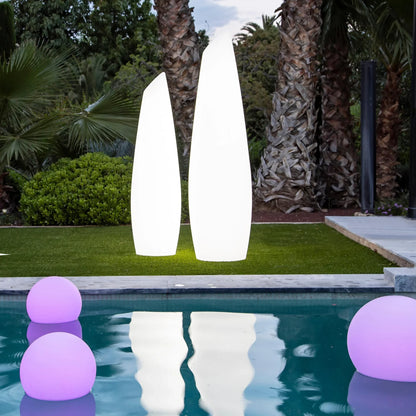 Josh & Tate - LumaSphere Wireless Mood Lamp - Two tall white outdoor lamps and purple漂浮球 in a pool with palm trees in the background