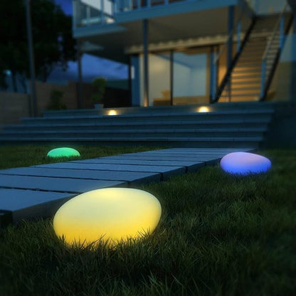 Colorful outdoor lights on grass near a modern house