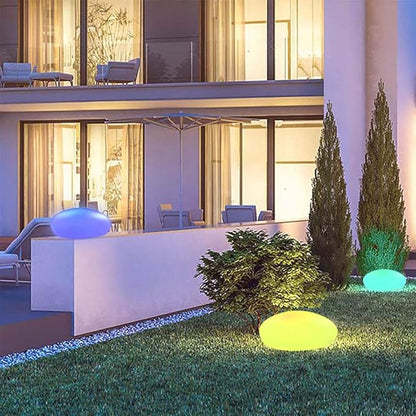 Modern outdoor setting with decorative lights on grass in front of a building.
