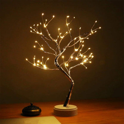 Decorative LED tree on a wooden surface with a dark background