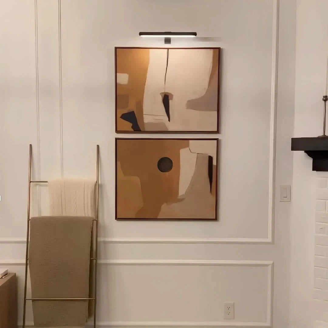 Josh & Tate -  LumeArt Wireless Art Lamp - Two abstract wall art pieces on a neutral wall with a towel rack and light fixture.