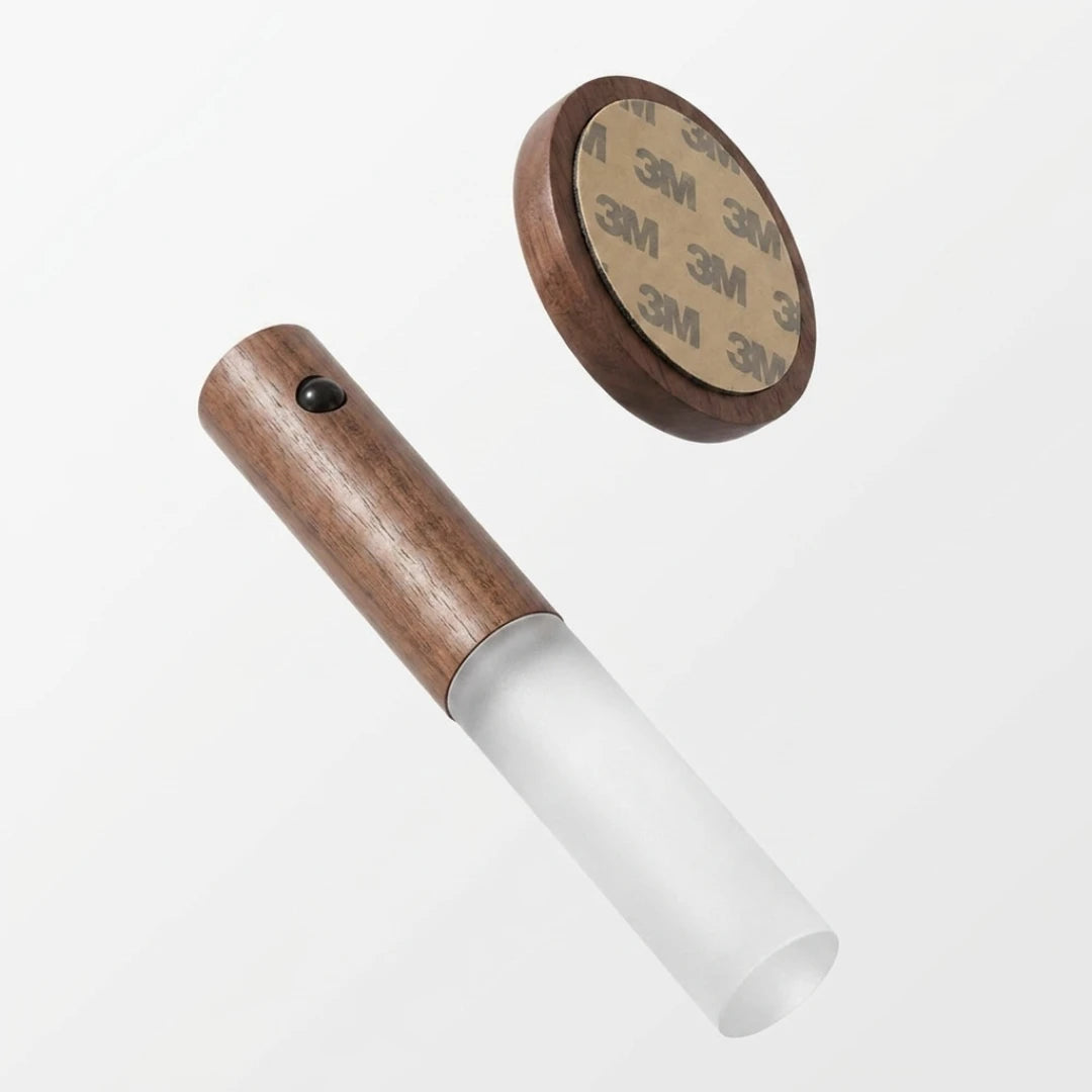 Josh & Tate - LumiDock™ Motion Wall Light - Wooden tool with white handle and circular brown component featuring 3M adhesive tape on a white background