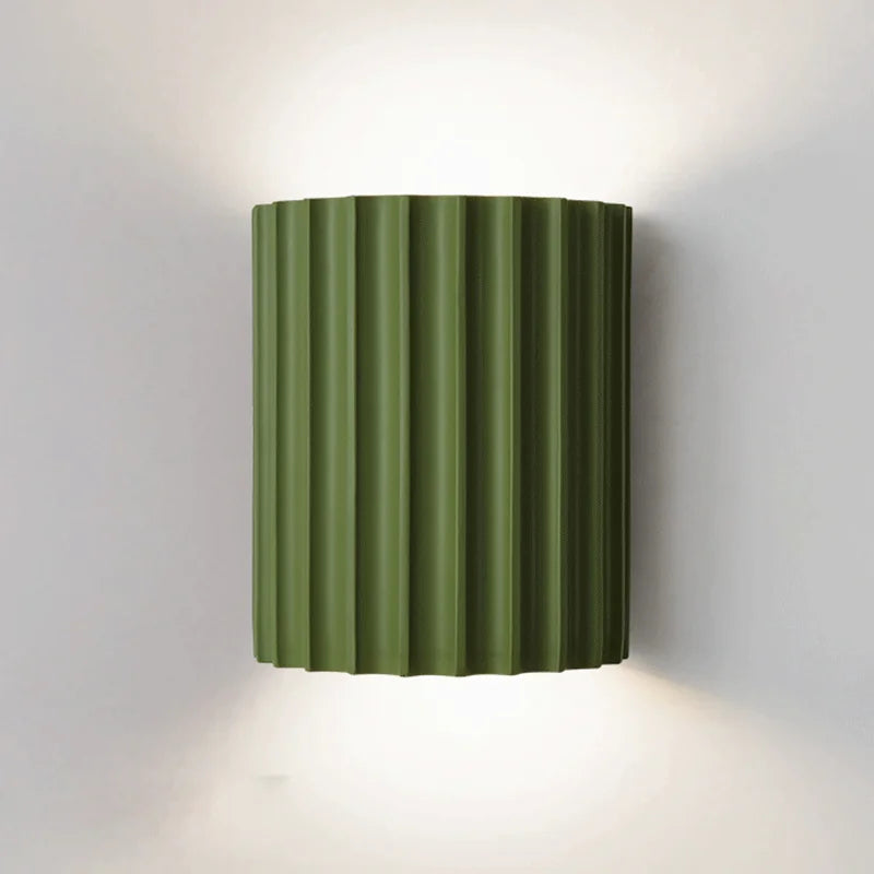 Green wall-mounted lamp with ribbed design on a white background