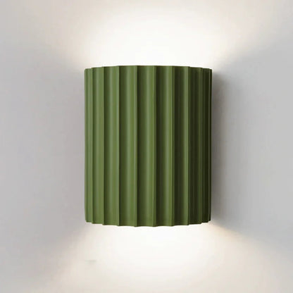 Green wall-mounted lamp with ribbed design on a white background