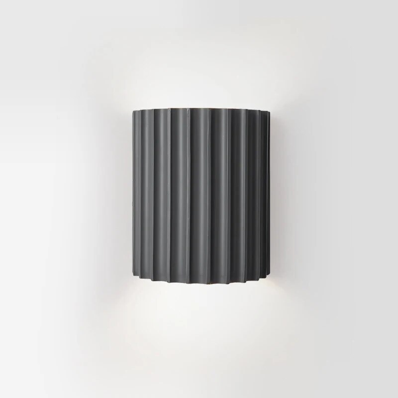 Black wall-mounted lamp with ribbed design on a white background