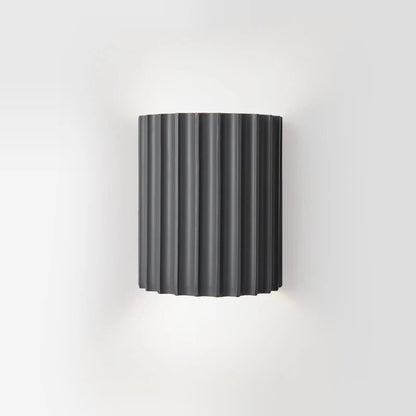 Black wall-mounted lamp with ribbed design on a white background
