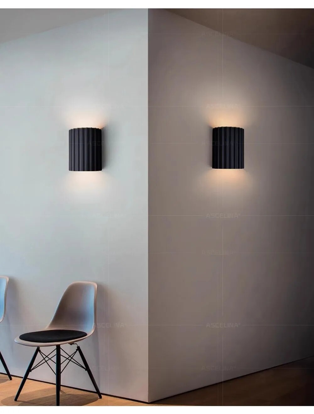 Two black wall lights on opposite walls of a room with a chair.