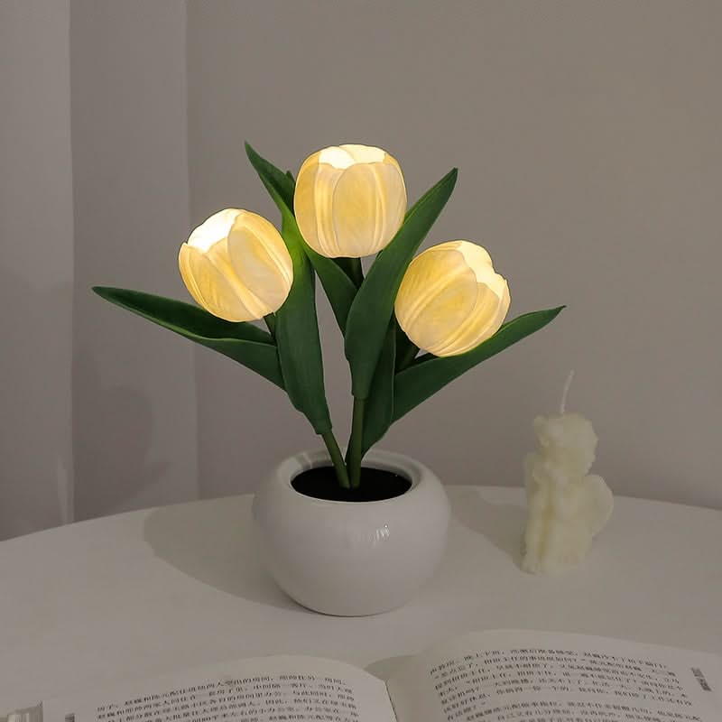 Decorative lamp shaped like a potted plant with glowing yellow lights on a table.