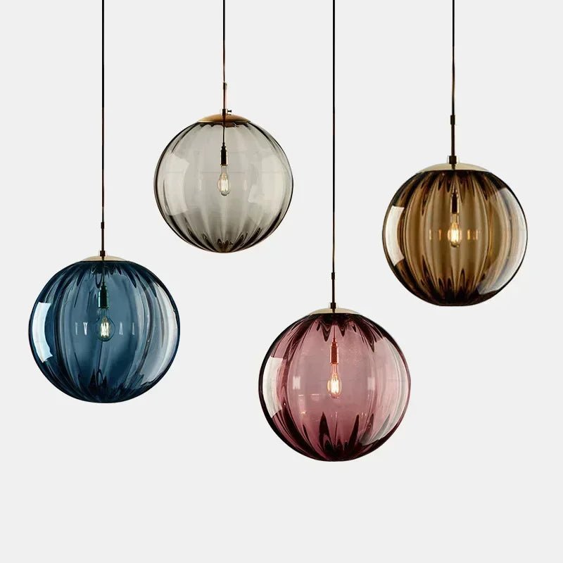 Set of four colorful glass pendant lights on a white background