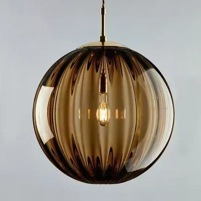 Spherical pendant light with a brown glass shade on a gray background