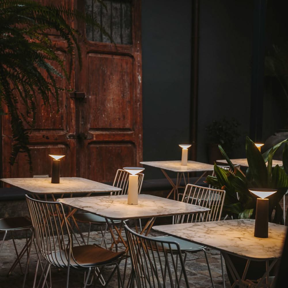 Dining area with marble tables and chairs, dimly lit ambiance.