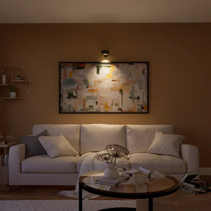 Cozy living room with a white sofa, coffee table, and wall art.