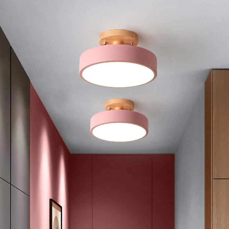 Two pink ceiling lights with wooden accents on a ceiling.