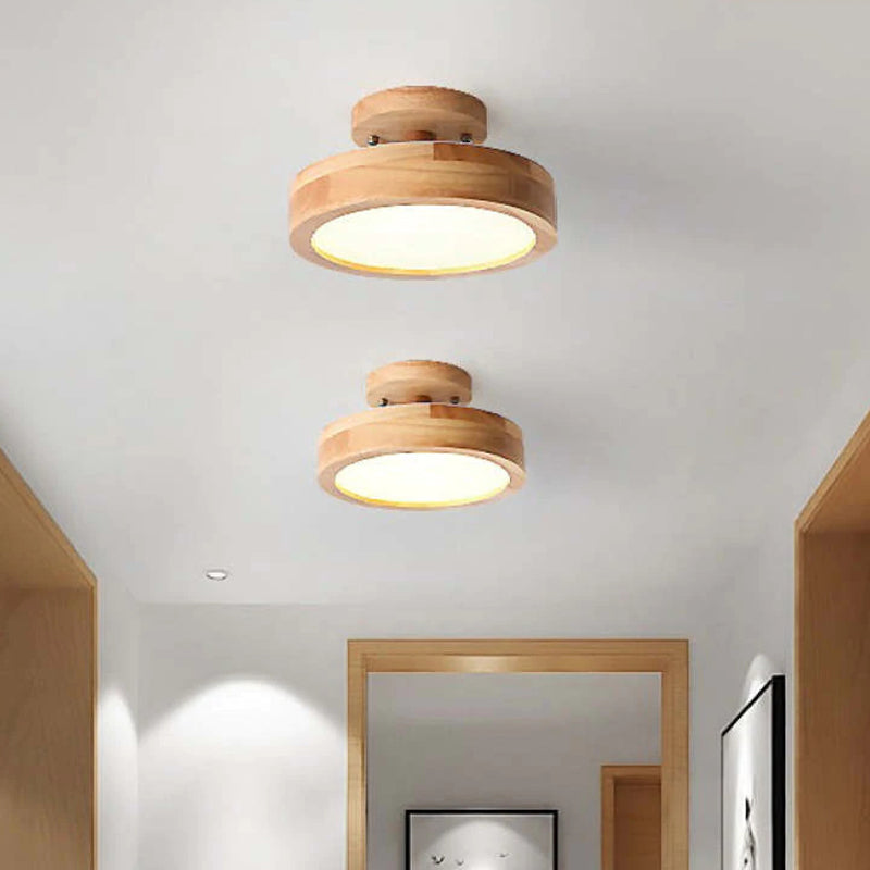 Two wooden ceiling lights in a room with neutral walls and wooden frames.