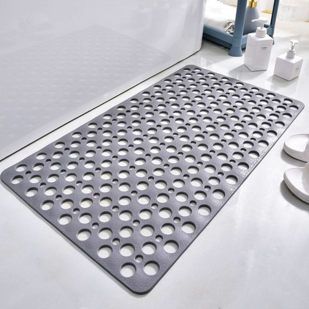 Gray bath mat with circular holes on a bathroom floor