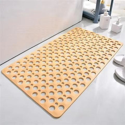 Beige bath mat with circular holes on a bathroom floor