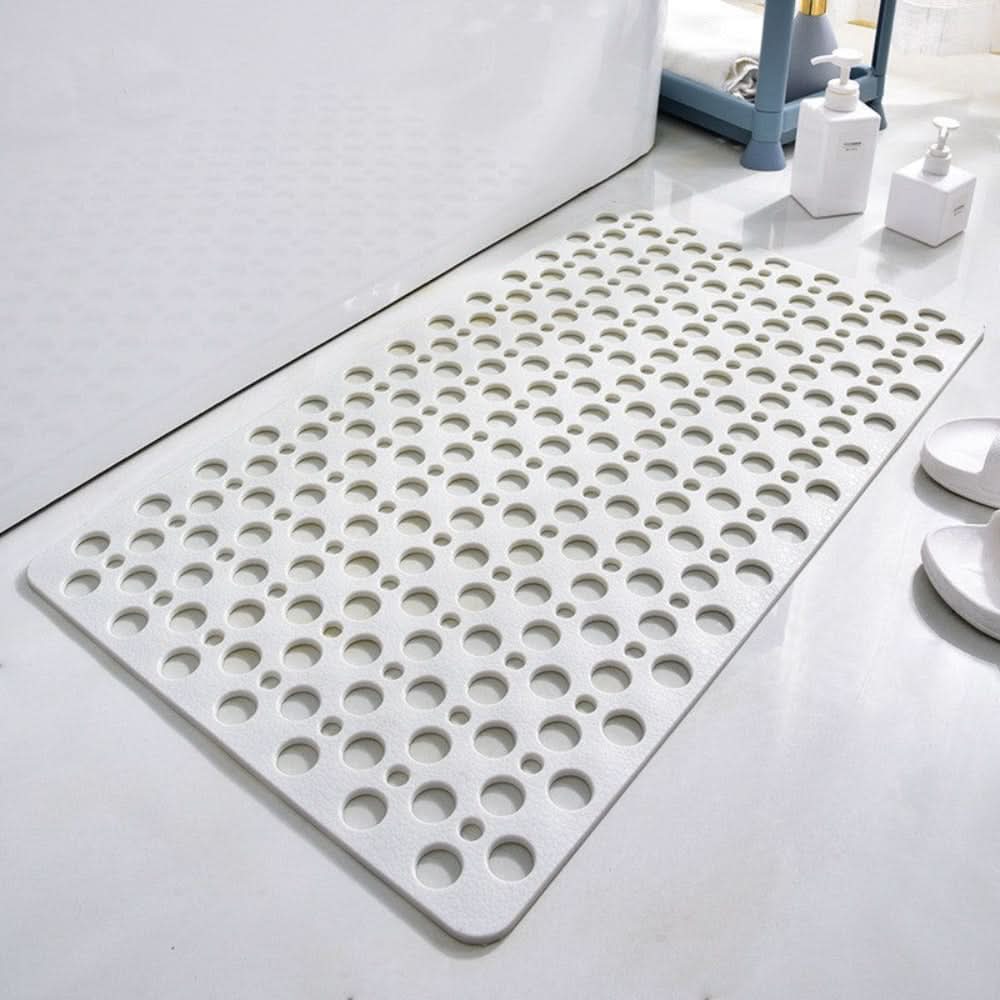 White bath mat with circular holes on a bathroom floor