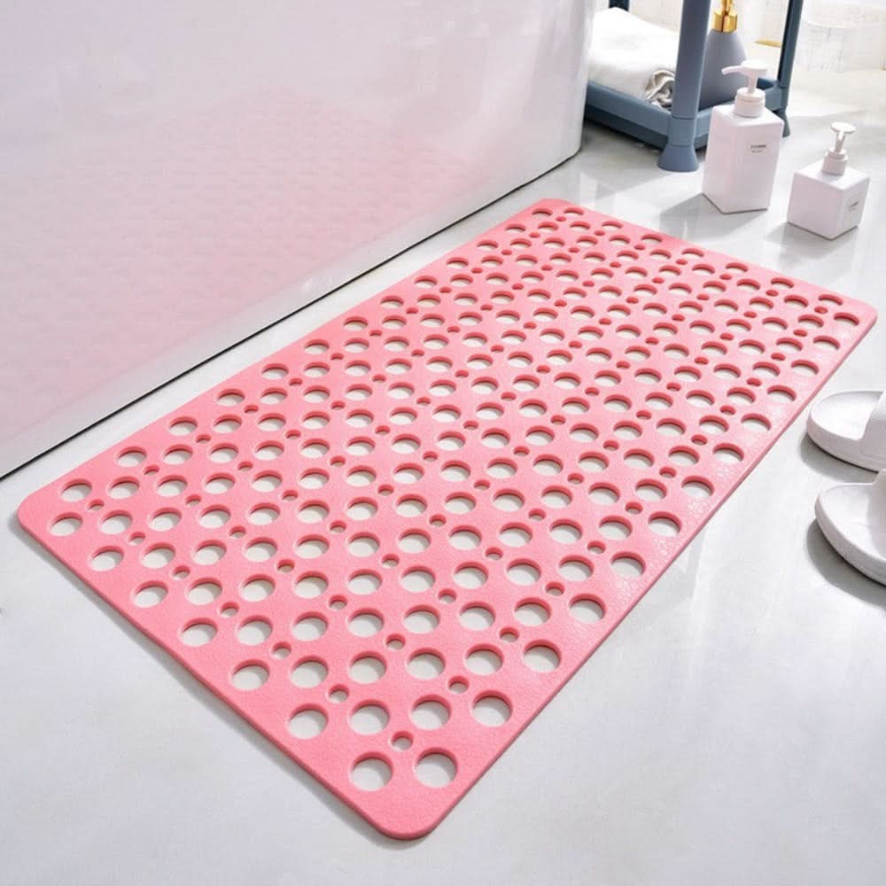Pink bath mat with circular holes on a bathroom floor