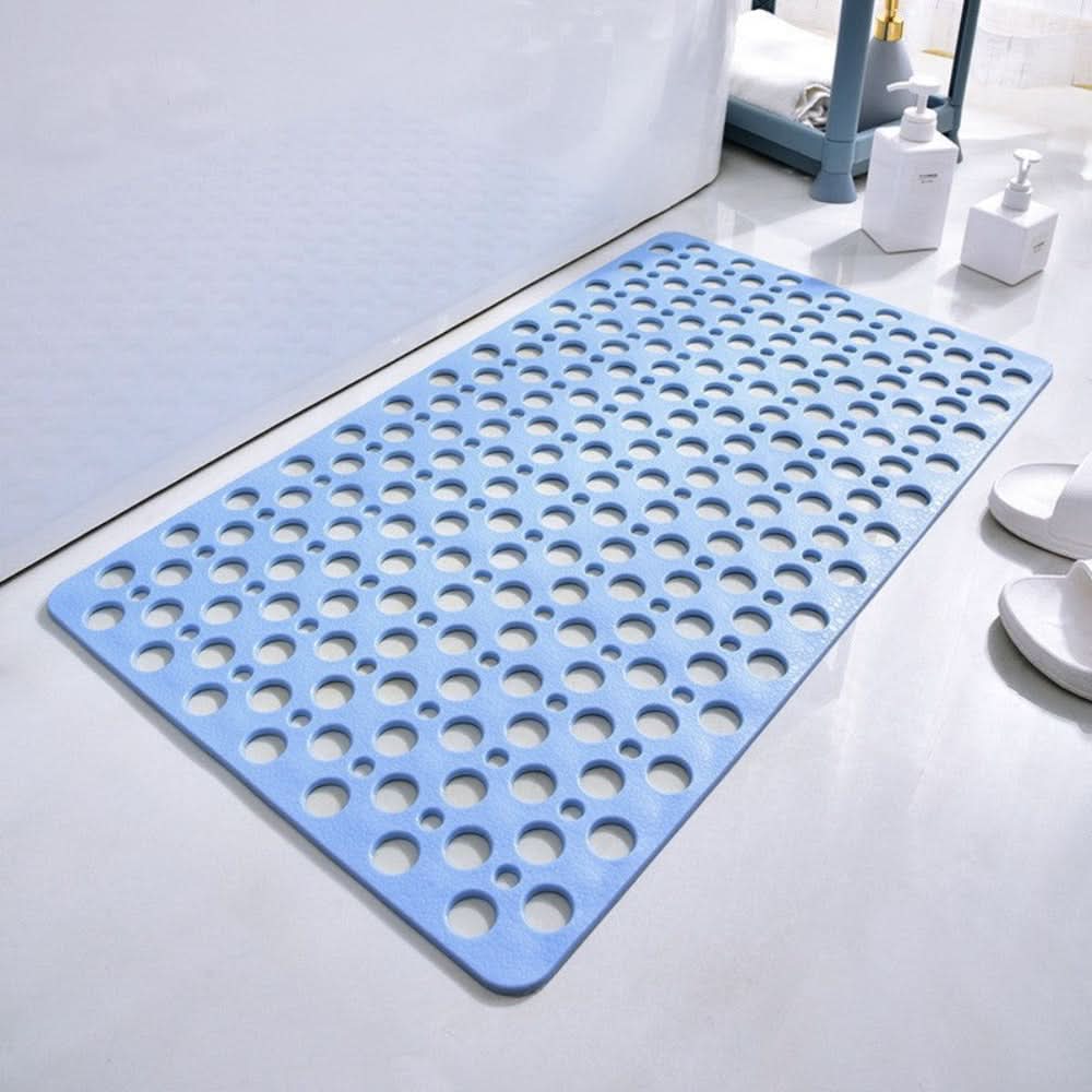Blue bath mat with circular holes on a bathroom floor
