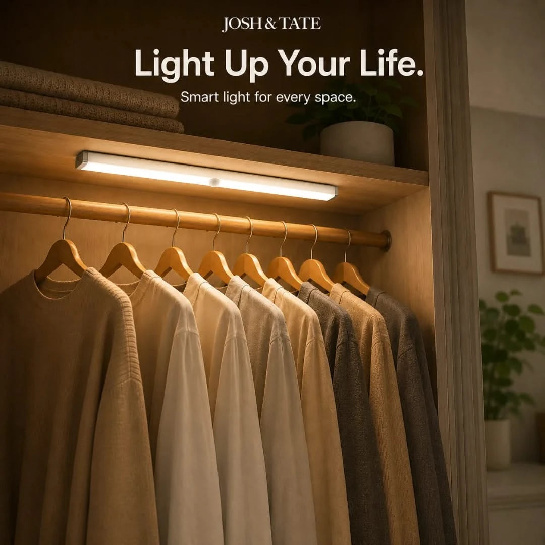 Josh & Tate - MagBar™ Motion-Sensing LED Light - Clothing rack with shirts illuminated by a smart light labeled 'Josh & Tate' in a home setting.