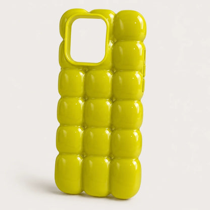 Josh & Tate - MarshBubble™ Puffy iPhone Case - A bright yellow-green glossy phone case with a 3D bubble grid pattern and a large camera cutout, shown on a light gray background.