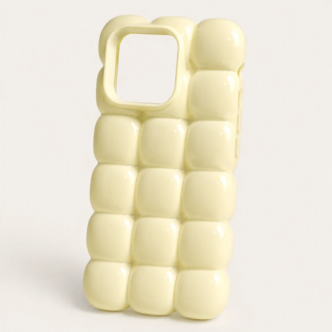 Josh & Tate - MarshBubble™ Puffy iPhone Case - A pale yellow phone case with a 3D bubble grid pattern and a square camera cutout, shown on a light gray background.
