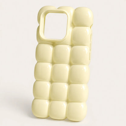 Josh & Tate - MarshBubble™ Puffy iPhone Case - A pale yellow phone case with a 3D bubble grid pattern and a square camera cutout, shown on a light gray background.