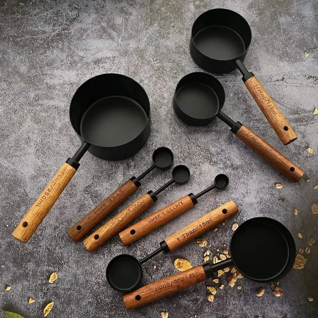 Josh & Tate - Measuring Spoon Set (Wood Handle) - Set of black measuring cups with wooden handles on a gray surface