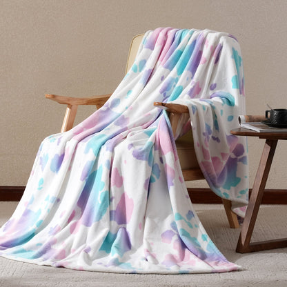 Pastel patterned blanket draped over a wooden chair against a beige wall.