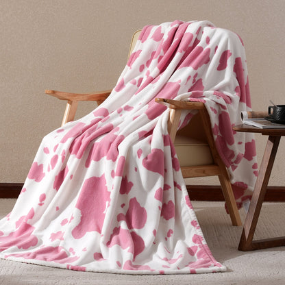 Pink and white patterned blanket draped over a wooden chair against a beige wall.