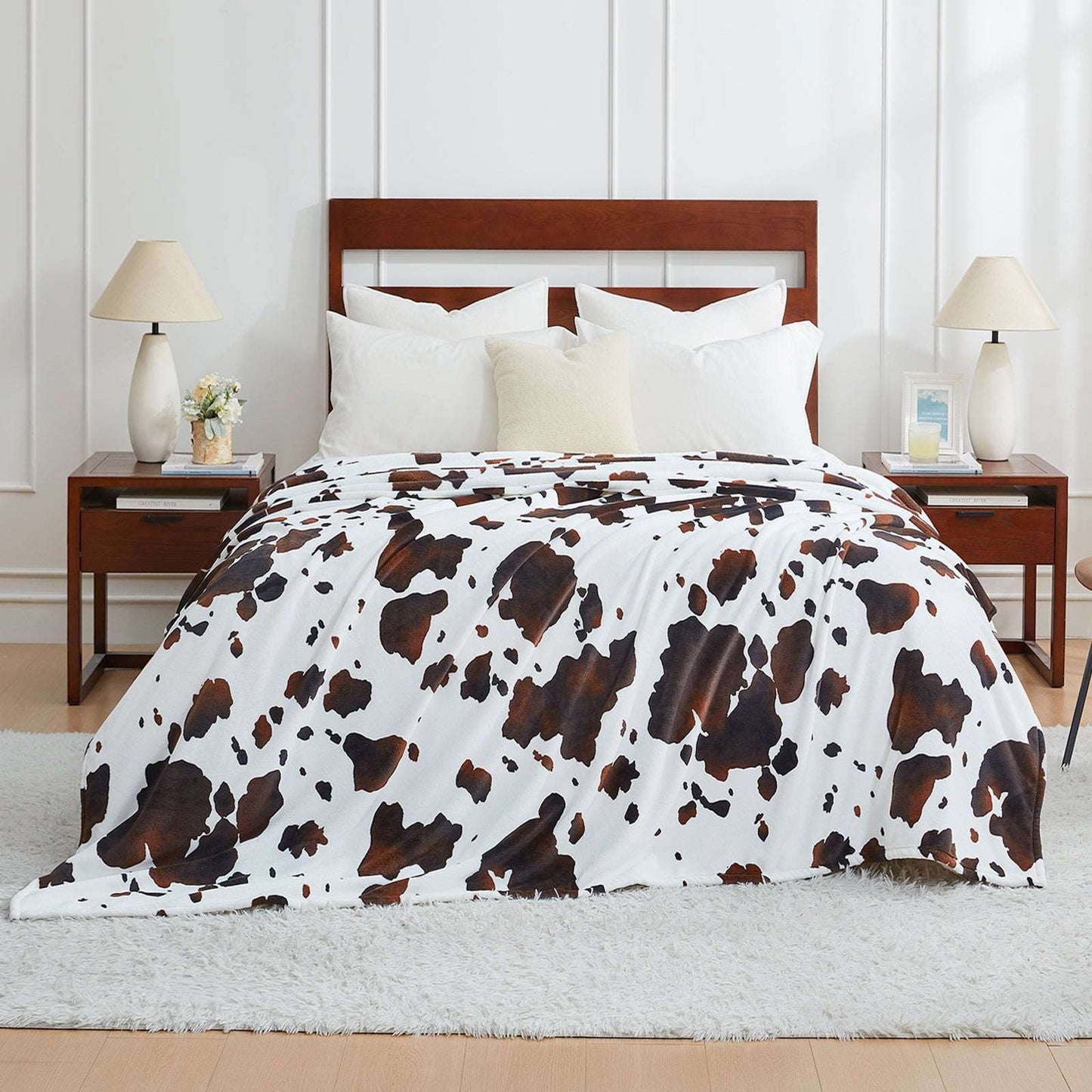 Bed with cow print comforter in a bedroom setting